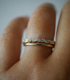 a woman's hand with a wedding ring on her finger, showing the diamond band