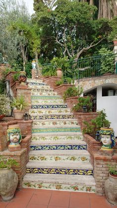 an outdoor staircase with potted plants and pots on the steps leading up to it