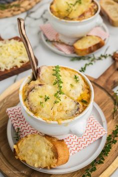 a bowl of food on a plate with bread