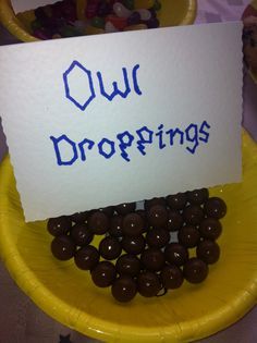 a sign that says ouu droppings on top of chocolate candies in a yellow bowl