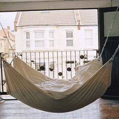 a white hammock hanging from a balcony