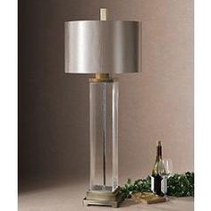 a glass table lamp with a bottle of wine on the bottom and a christmas decoration behind it