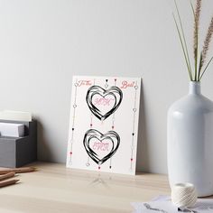 two hearts drawn in black and pink on a white background art boarder next to a vase