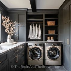 a washer and dryer in a room with dark wood cabinets, white marble counter tops