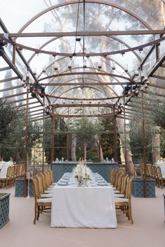 an outdoor dining area with tables, chairs and white tablecloths on the table