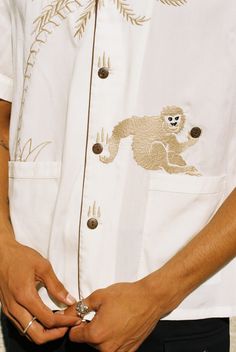 Monkeying around has its moments. Unisex SizingTencel™This style is also available in a chocolate colorway here.DETAILS Featuring a carefully embroidered monkey catching a falling coconut (button). 🌴🐒 Embroidered palm tree arches into the placket which features buttons standing in for coconuts. 🌴🐒 Lower patch pockets and box pleat on back for ease of movement. 🌴🐒 Embroidered Tombolo logo on right sleeve. 🌴🐒 Detailed with piping and a contrast collar. SIZING Aaron is 6'2" with a 32" waist Monkey Business, Contrast Collar, Box Pleats, Shirt And Pants, Palm Tree, Hawaiian Shirt, Piping, Chef Jackets, Button Up Shirts