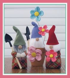 three garden gnomes with flowers and gardening utensils