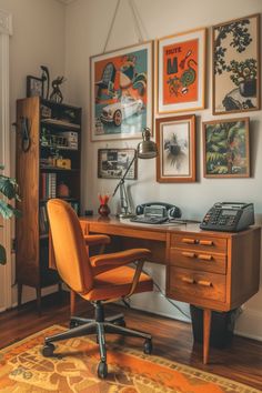 a desk with a phone, telephone and pictures on the wall above it in a home office