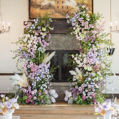 a fireplace decorated with flowers and greenery