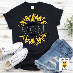 a sunflower with the word mom on it next to some denim shorts and sneakers