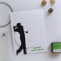 a birthday card with a golf player on it next to a rubber stamp and some other items