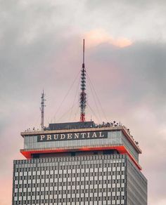 the top of a tall building with a radio antenna on it's roof in front of a cloudy sky