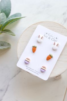 the earrings are made out of plastic and have carrots in them on top of a card