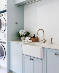 a laundry room with washer and dryer next to each other in front of cabinets