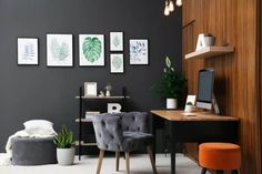 a home office with black walls and grey chairs