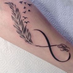 a tattoo with a feather and an infinite sign on the arm that reads, love