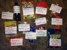 some candy bags and signs are on the floor next to a bottle of soda, which is also labeled with words