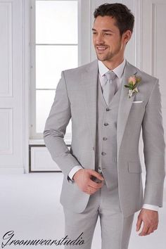 a man in a gray suit with a flower on his lapel