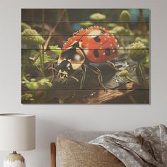 a ladybug sitting on top of a bed next to a wall mounted painting