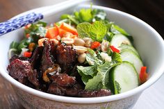 a bowl filled with meat and vegetables on top of a table