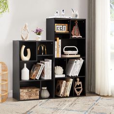 a black book shelf with books and other items on top of it in a living room