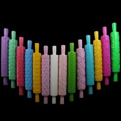 several different colored toothbrushes are lined up in a row on a black background