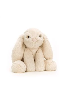 a white stuffed rabbit sitting on the ground