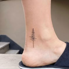 a small pine tree tattoo on the ankle