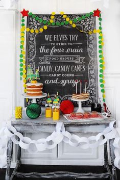 an image of a christmas party with cake and candy on the table, decorated with white streamers