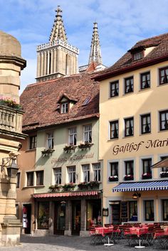 several buildings with tables and chairs in front of them