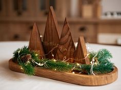 a wooden christmas decoration with pine cones and lights