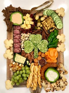 a wooden tray filled with lots of different types of food and snacks on top of each other