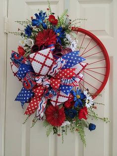 a red white and blue wreath hanging on a door