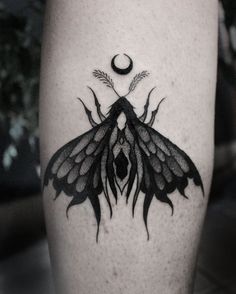 a black and white photo of a butterfly tattoo on the right leg, with an crescent moon in the background