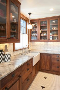 a kitchen with wooden cabinets and marble counter tops