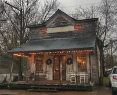 an old fashioned store with christmas lights on the front and side of it's building