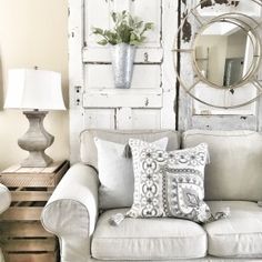 a living room filled with furniture and a mirror on top of a wooden wall next to a lamp