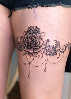 a woman's thigh with a rose tattoo on it