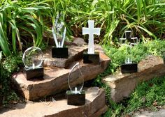 several glass crosses sitting on top of some rocks