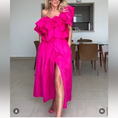 a woman in a pink dress is posing for the camera