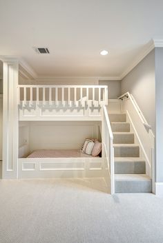 there is a bunk bed in the middle of this room with stairs leading up to it