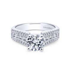 a white gold engagement ring with two rows of diamonds on the band and a round center stone