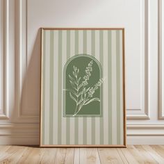 a green and white striped wall with a picture frame on the floor in front of it