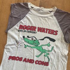 "This piece is a rare vintage sleeveless baseball style tee from the 1980s for Roger Waters, a member of Pink Floyd. This white and grey shirt is for Waters' 1985 Pros and Cons of Hitch Hiking North American Tour. It has big graphics on either side for the tour and on the back it says 'Plus Some Old Pink Floyd Stuff'. -Made in West Germany -Single Stitch -Care and content tag is completely washed out -Some yellowing throughout Tag Size: N/A *refer to measurements for true fit* Pit to Pit: 16.5\" Retro Letter Print Tank Top, Vintage Sleeveless T-shirt With Graphic Print, Retro Crew Neck Tank Top With Letter Print, Retro Cotton Muscle Tee With Graphic Print, Vintage Muscle Tee With Crew Neck For Streetwear, Vintage Sleeveless Cotton T-shirt, Vintage Graphic Print Muscle Tee With Crew Neck, Vintage Cotton Muscle Tee With Graphic Print, Vintage Cotton Muscle Tee With Crew Neck