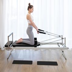 a woman is doing pivots on a rowing machine