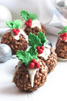 three christmas puddings on a plate with holly decorations