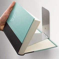 a person holding an open book in their left hand with the cover folded over it