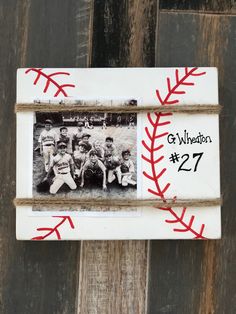 an old photo frame with baseballs and the number twenty seven in red on it