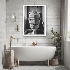 a white bath tub sitting next to a toilet in a bathroom under a framed photo