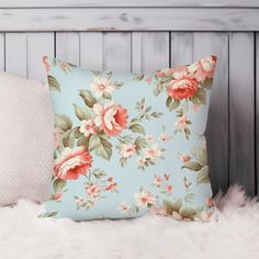 a blue pillow with pink flowers on it